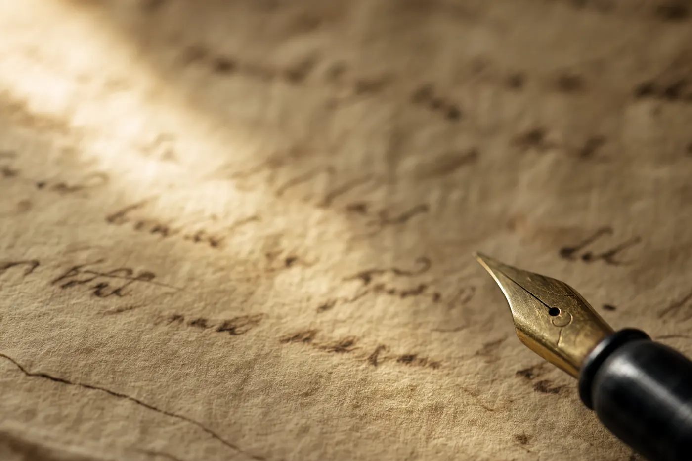 Aged parchment with handwritten text and a brass fountain pen